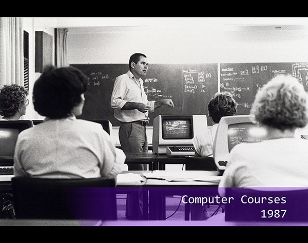 a teacher lecturing a class about computers in 1987