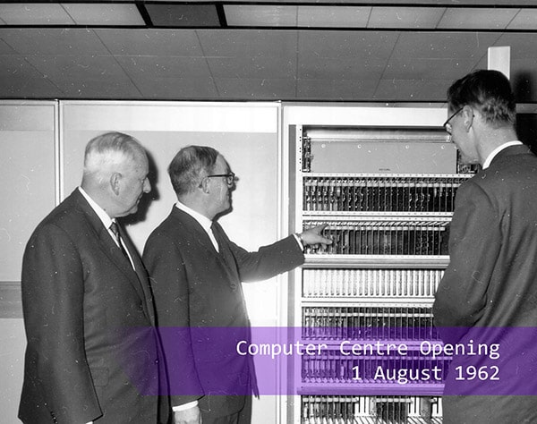 Three men looking at the computer at the Computer Centre opening in 1962