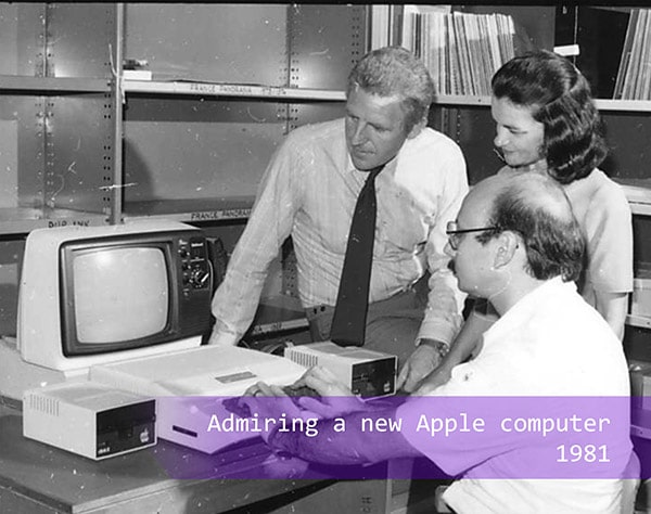 staff admiring a new Apple computer in 1981